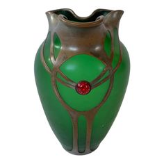 a green and gold vase with a red bead on the top is shown against a white background