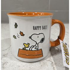 a ceramic coffee mug with a snoopy cartoon on it's side and the words happy fall