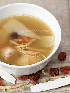 a white bowl filled with soup next to some raisins