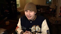 a man wearing a beanie sitting at a table