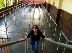 a woman is walking up some stairs with her arms out and smiling at the camera