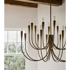 a large chandelier hanging from the ceiling in a room with white walls and wooden beams