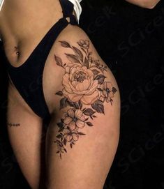 a woman's thigh with flowers and leaves on it