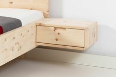 a bed with a wooden headboard and foot board next to a night stand that has a red blanket on it