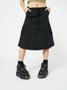 Shop this cargo midi skirt in black. Featuring side utility pockets with straps, zip fly with button fastening, belt loops and drawstring regular waist. Made from 100% cotton. Model wears size 24" and is 180 cm | 5'11" tall. Goblincore Outfits, Goblincore Fashion, Cargo Skirt Outfit, Cargo Midi Skirt, Edgy Tops, Black Cargo, Into The Woods, Cargo Skirt, Dress Hats