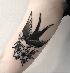 a black and white bird tattoo on the arm