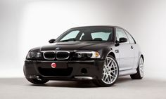 a black and white car is parked in a studio area with its hood down on it's headlamps