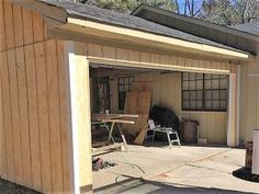 a garage with a table and chairs in the back yard, next to a shed