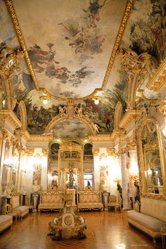 an ornately decorated room with couches and paintings on the ceiling