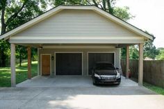 a car is parked in the driveway of a house that has a carport attached to it