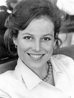 a black and white photo of a woman smiling