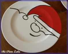 a white plate with a drawing of a santa clause on it and a knife in the middle