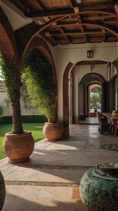 an outdoor dining area with large vases on the floor