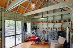 a room filled with lots of potted plants on shelves next to a door and windows