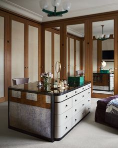 an elegant bedroom with mirrored closet doors and dresser in the corner, along with a bed