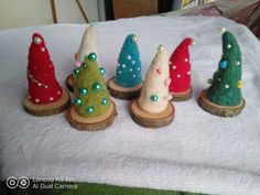 small christmas trees are sitting on wood slices