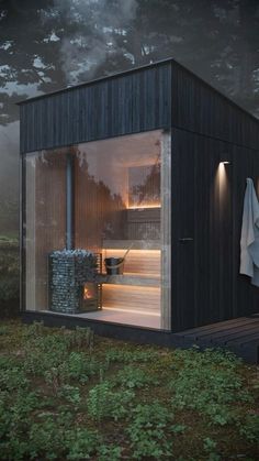 a small house with an open door and glass walls on the outside is lit up at night