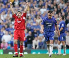 two soccer players celebrating on the field with their arms in the air and people watching