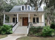 a white house with trees and bushes around it