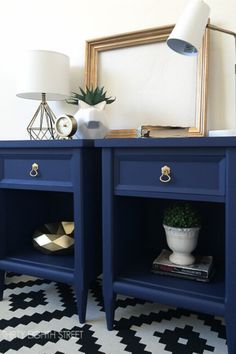 two blue nightstands side by side on a black and white floor with a mirror above them