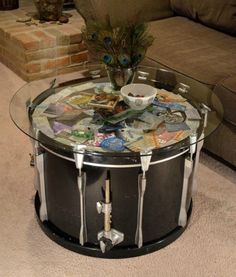 a glass table topped with magazines and a peacock figurine sitting on top of it