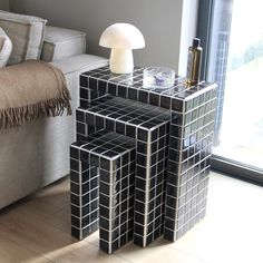 three black and white cubes stacked on top of each other in front of a window