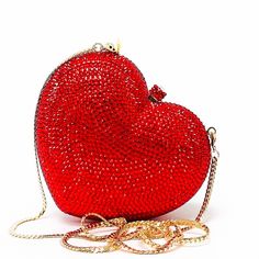 Red Heart Novelty Purse Clutch is a beautiful mini clutch covered in radiating ruby red crystals. This stunning piece is complete with gold color hardware and removable gold snap hook chain. Wear it in hand, on shoulder or as crossbody. It is the perfect statement clutch for a glamorous ensemble. Beautiful and functional, this clutch can hold securely your keys, cards, and other small essentials. Details: Measurement: 5in length x 4in high x 1.5in width Color: Red crystals Lining: golden vegan l Glamorous Heart-shaped Bag For Gift, Heart-shaped Formal Bag For Valentine's Day, Glamorous Gift Bag For Valentine's Day, Glamorous Heart-shaped Gift Bags, Glamorous Valentine's Day Gift Bag, Valentine's Day Heart-shaped Evening Bag, Luxury Party Bags For Valentine's Day, Luxury Clutch With Rhinestones For Gift, Heart-shaped Evening Bag For Valentine's Day Formal