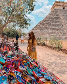 a woman standing next to a table full of colorful plates