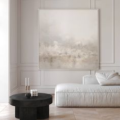 a living room with white furniture and a large painting hanging on the wall above it