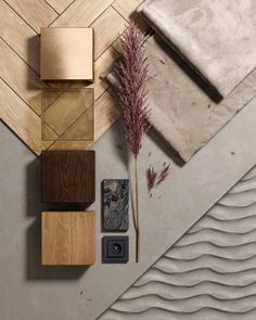 an arrangement of wood, tile and other items on a table with a plant in the middle