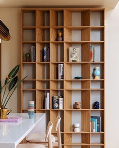 a room filled with lots of wooden bookshelves next to a white counter top