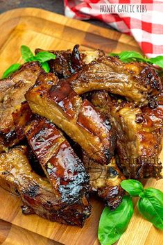 grilled pork chops on a cutting board with basil leaves and red checkered table cloth