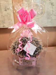 a basket filled with lots of chocolate covered in pink ribbon