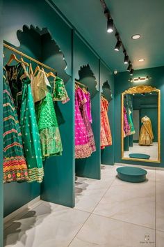 there are many dresses on display in the store, and one is green with gold trim