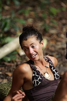 a young woman sitting on the ground smiling