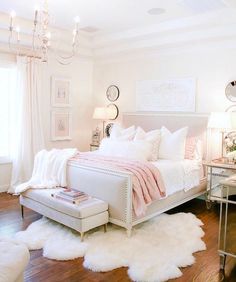 a bedroom with white fur rugs and chandelier