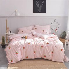 a bed with pink sheets and strawberry print on it