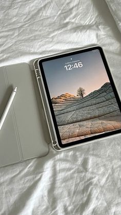 an ipad with a pen sitting on top of it