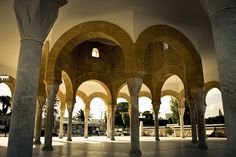 the inside of an old building with columns and arches