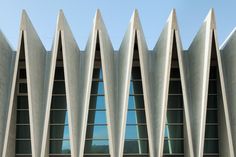 the side of a building with many windows and curved concrete structures on it's sides