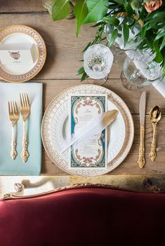 the table is set with plates, silverware, and napkins for an elegant dinner