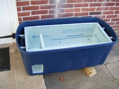 a large blue container sitting next to a brick wall