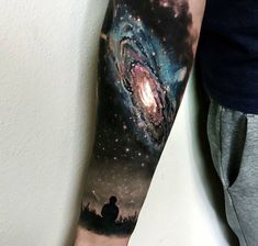 a man with a tattoo on his arm that has an image of the milky and stars