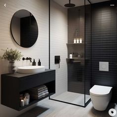 a black and white bathroom with a toilet, sink, shower stall and mirror on the wall