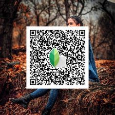 a woman sitting on top of a pile of leaves next to a qr code