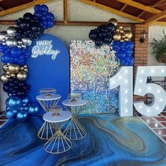 a blue and gold themed birthday party with balloons, lights and decorations on the floor