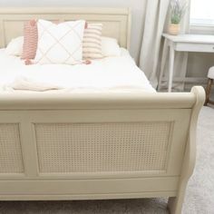 a white bed sitting in a bedroom next to a window