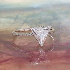 a white diamond ring sitting on top of a table