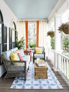 the porch is decorated with wicker furniture and colorful pillows, along with an area rug that says own your home