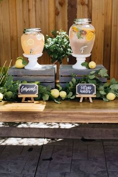 two vases filled with lemonade sitting on top of a wooden table